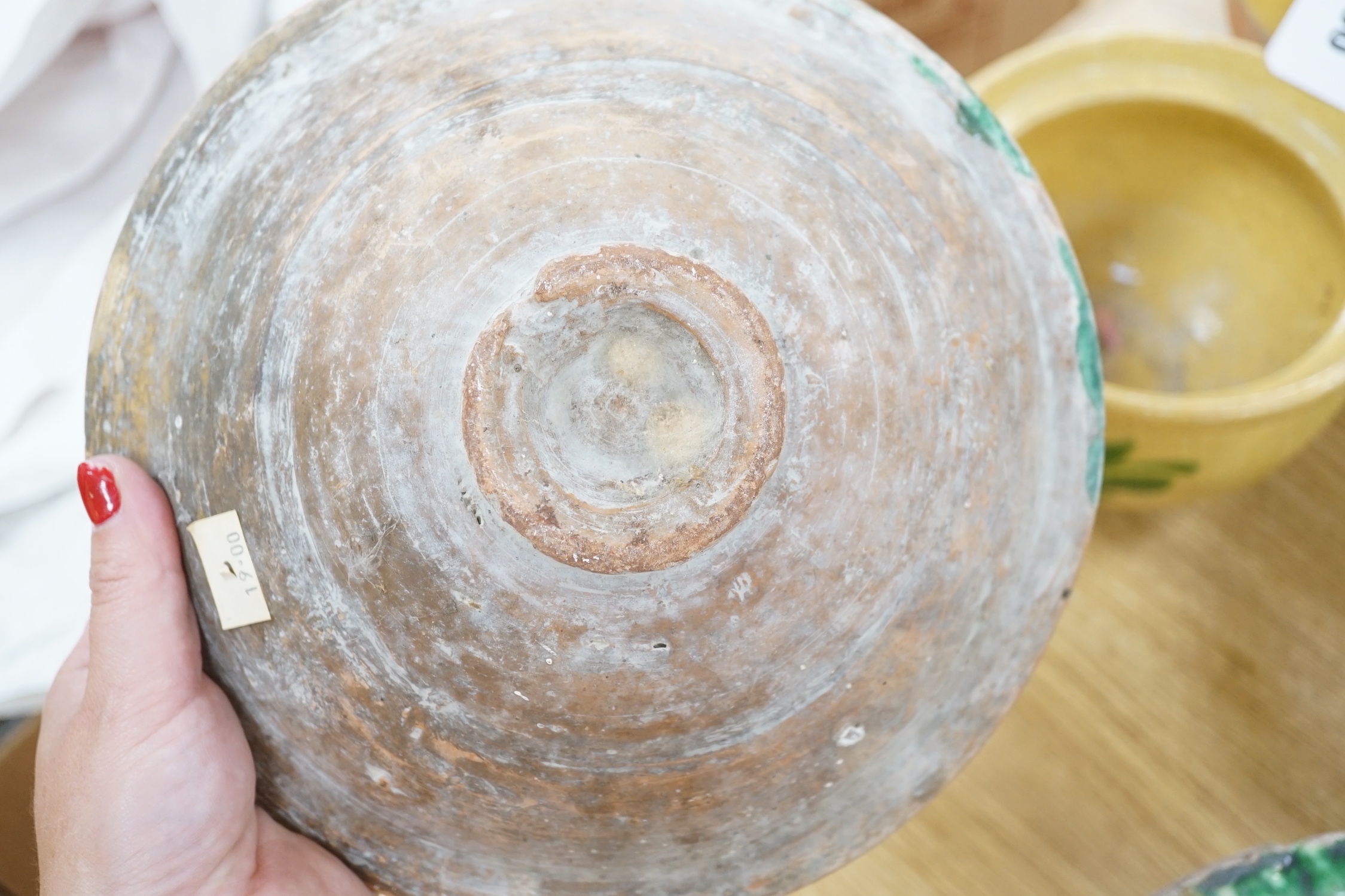 A group of Mediterranean slip decorated pottery dishes, a jar and cover and a bowl, predominantly with yellow and green grounds, the largest 26cm in diameter